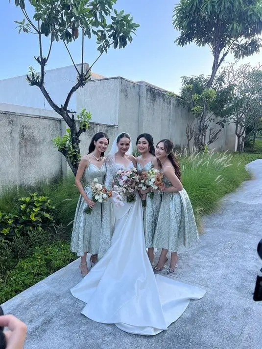 Untuk resepsi pernikahannya di Bali, Enzy memilih gaya gaun klasik dengan material fabric mewah nuansa silver dan gold. [Foto: Instagram @enzystoria]