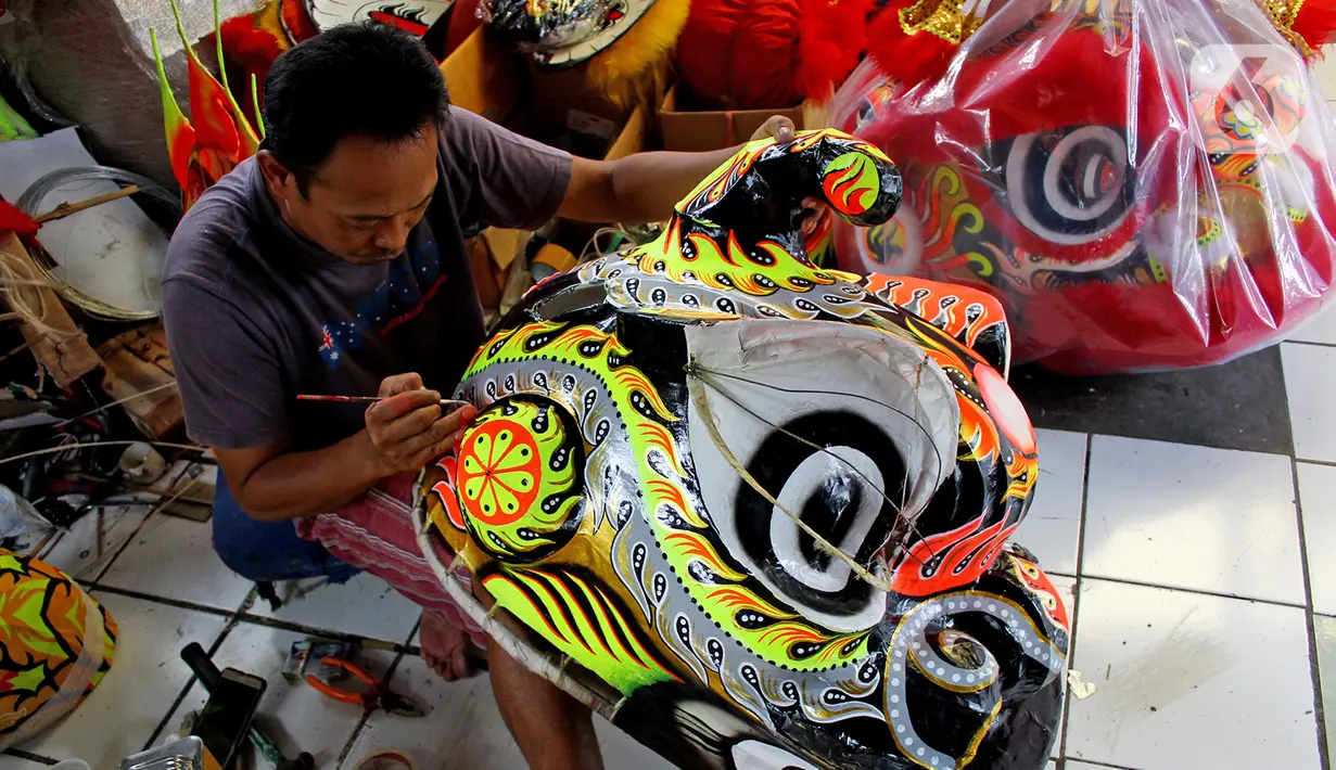 Lily Hambali sedang melakukan pelukisan kerangka barongsai di Jalan Roda, Babakan Pasar, Bogor, Jawa Barat, Selasa (21/1/2020). Jelang hari raya Imlek pengrajin rumahan barongsai dan liong Lily Hambali ramai pemesanan. (merdeka.com/Magang/Muhammad Fayyadh)