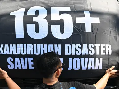Seorang peserta aksi dalam protes di sepanjang jalan sebelum menghadiri upacara peringatan di Malang, Jawa Timur pada tanggal 1 Oktober 2023. (Juni KRISWANTO/AFP)
