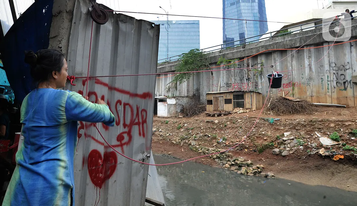Pemilik warung menarik ember saat melayani pembeli di seberang Kali Mampang, Mampang Prapatan, Jakarta Selatan. (merdeka.com/Arie Basuki)
