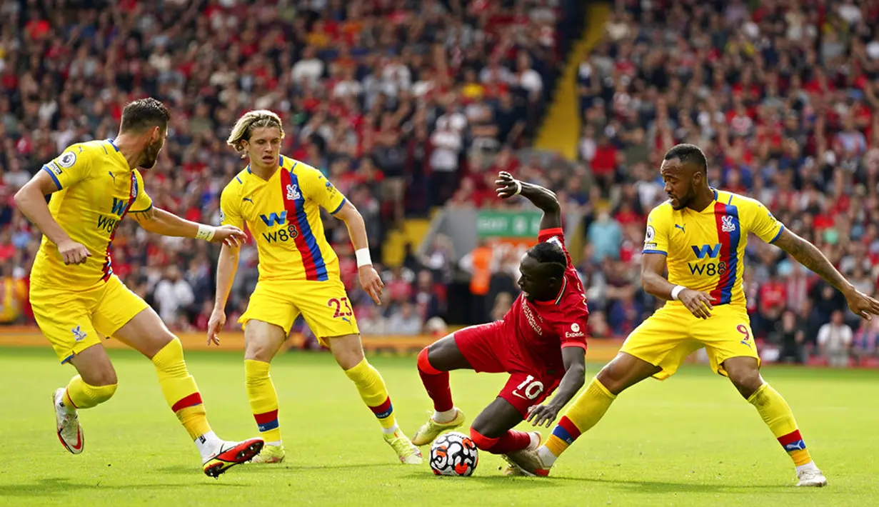 Pemain Liverpool Sadio Mane dilanggar oleh pemain Crystal Palace Jordan Ayew (kanan) pada pertandingan Liga Inggris di Stadion Anfield, Liverpool, Inggris, Sabtu (18/9/2021). Liverpool menang telak 3-0. (AP Photo/Jon Super)