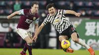 Penyerang Burnley, Ashley Barnes merebut bola dari bek Manchester United, Harry Maguire dalam lanjutan Liga Inggris di Turf Moor, Rabu (13/1/2021) dini hari WIB. Manchester United sukses mengalahkan Burnley dengan skor tipis 1-0. (AP Photo/Jon Super, Pool)