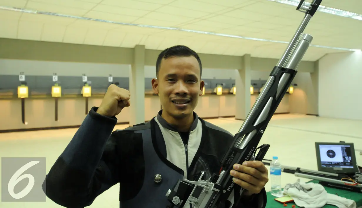 Petembak Indonesia, M Hasan Busri mengangkat tangan usai meraih perak 39th South East Asia Shooting Championships kelas 10m Air Rifle Men di Jakarta, Kamis (19/11/2015). Hasan mencatat 200,2poin. (Liputan6.com/Helmi Fithriansyah)