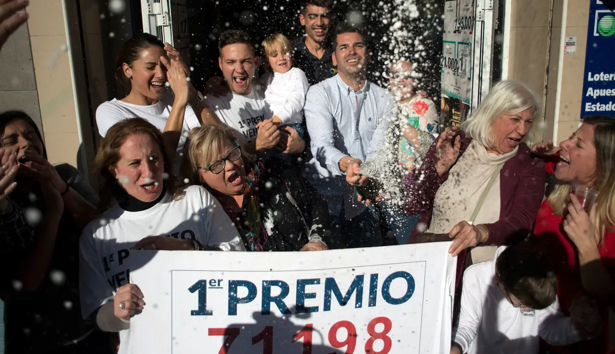 Penjual tiket undian dan pemenang merayakan kemenangan di sebuah toko lotre di Malaga, Spanyol (22/12). Natal tahun ini memberi keceriaan buat karyawan Sagrado Corazon di Campo de Criptana, Spanyol. (AFP Photo/Jorge Guerrero)