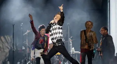 Penampilan Mick Jagger (tengah) saat konser Rolling Stones dalam tur 'No Filter' di Soldier Field, Chicago, Amerika Serikat, Jumat (21/6/2019). Jagger tampil memukau dengan aksinya yang energik di atas panggung. (Kamil Krzaczynski/AFP)