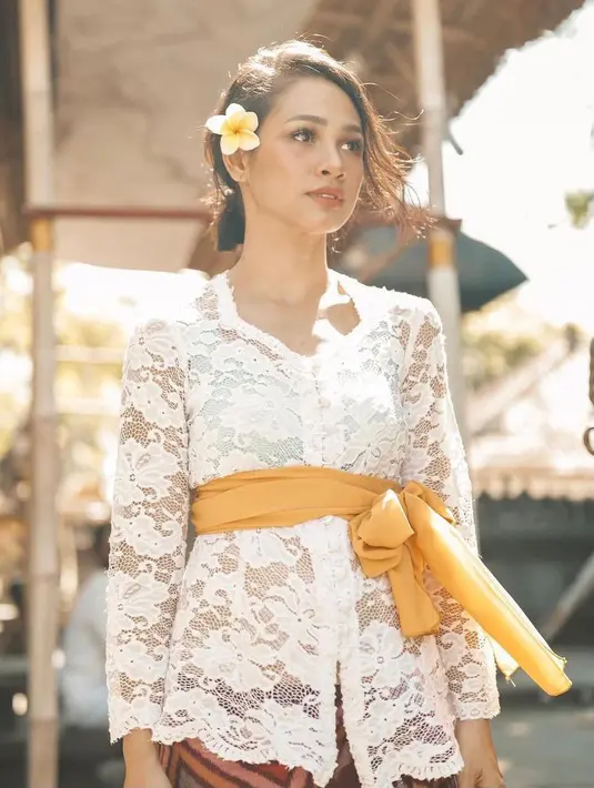 Andien memadukan kebaya putih dengan obi kuning. Obi adalah aksesori yang menjadi keunikan kebaya Bali. (Instagram/andienaisyah).