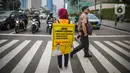 Relawan yang tergabung dalam Gerakan Mahasiswa Cegah Covid-19 membawa poster 'Ayo Lawan Corona' saat kampanye di Pelican Cross kawasan Thamrin, Jakarta, Senin (23/3/2020). (Liputan6.com/Faizal Fanani)