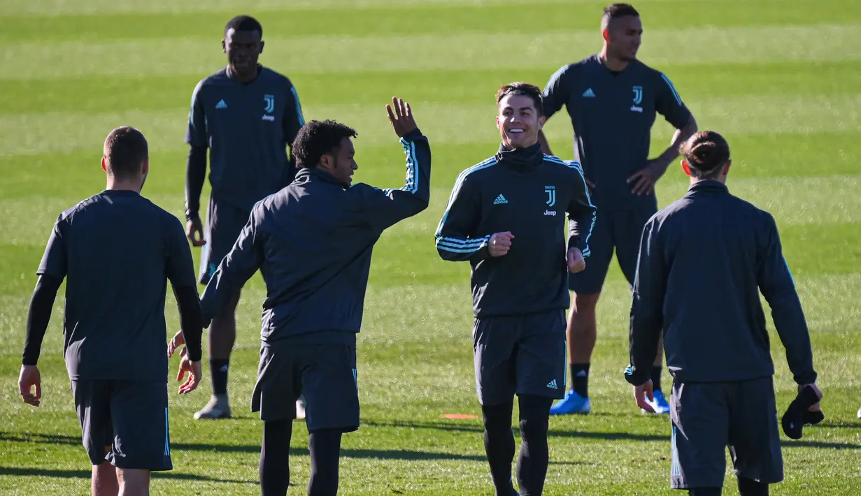 Gelandang Juventus, Juan Cuadrado (kedua kiri depan) dan Penyerang Juventus, Cristiano Ronaldo melakukan pemanasan selama sesi latihan tim di Turin, Italia (10/12/2019). Juventus akan bertanding melawan wakil Jerman, Bayern Leverkusen pada Grup D Liga Champions di BayArena. (AFP/Marco Bertorello)