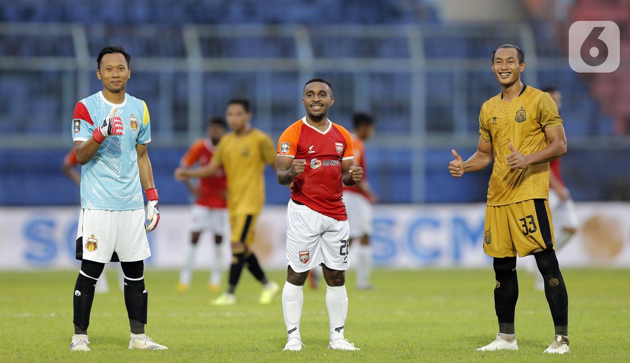 Pemain Borneo FC Samarinda Terens Owang Priska Puhiri (tengah) berpose bersama pemain Bhayangkara Solo FC Awan Setho Raharjo (kiri) dan Hansamu Yama Pranata usai pertandingan babak penyisihan Piala Menpora 2021 di Stadion Kanjuruhan, Malang, Jawa Timur, Senin (22/3/2021). (Bola.com/Arief Bagus)