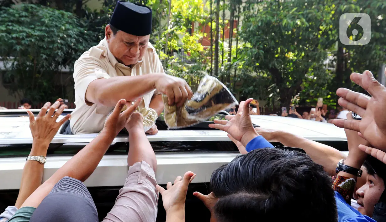 Seusai meninjau pelaksanaan program MBG, Presiden Republik Indonesia Prabowo Subianto menyapa warga sekaligus membagikan kaos dari atas kendaraannya. (Liputan6.com/Herman Zakharia)