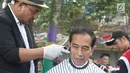 <p>Presiden Joko Widodo saat mengikuti acara cukur rambut massal di Garut, Jawa Barat, Sabtu (19/1). Tak hanya Jokowi, Menteri PUPR Basuki Hadimuljono serta Kepala Sekretariat Presiden Heru Budi Hartono ikut memangkas rambutnya. (Liputan6.com/Angga Yuniar)</p>