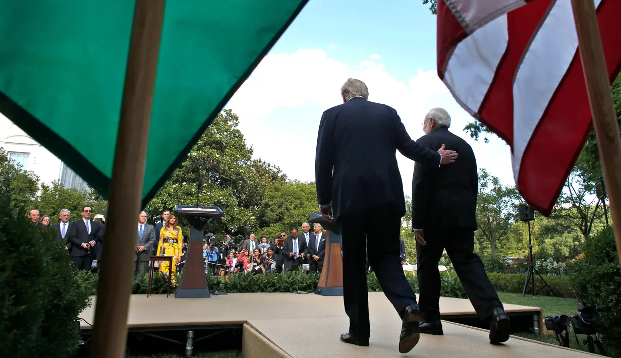 Presiden Donald Trump berjalan bersama Perdana Menteri India Narendra Modi ke Rose Garden untuk berpidato di Gedung Putih, Washington (26/6). (AP Photo / Alex Brandon)