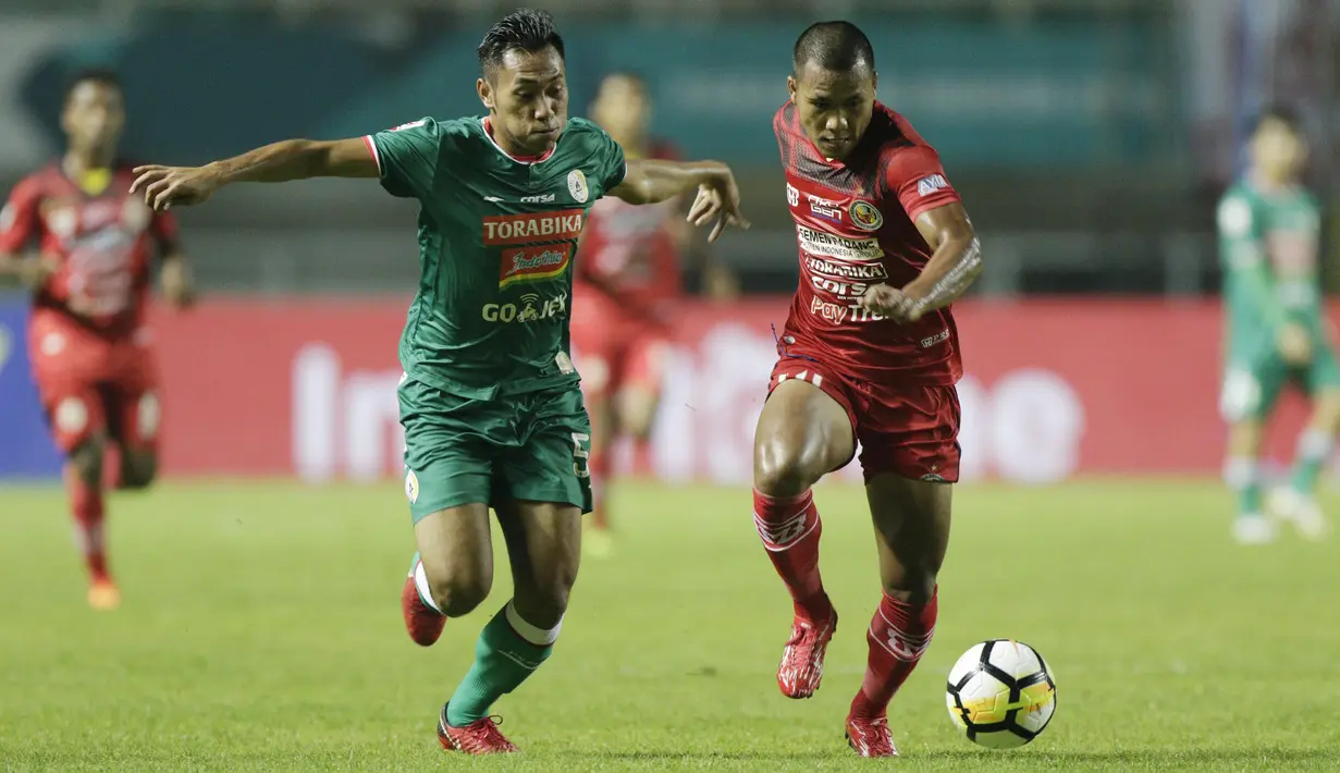 Striker Semen Padang, Riski Novriansyah, berebut bola dengan bek PSS Sleman, Asyraq Gufran, pada laga Liga 2 di Stadion Pakansari, Jawa Barat, Selasa (4/12). PSS menang 2-0 atas Semen Padang. (Bola.com/M. Iqbal Ichsan)