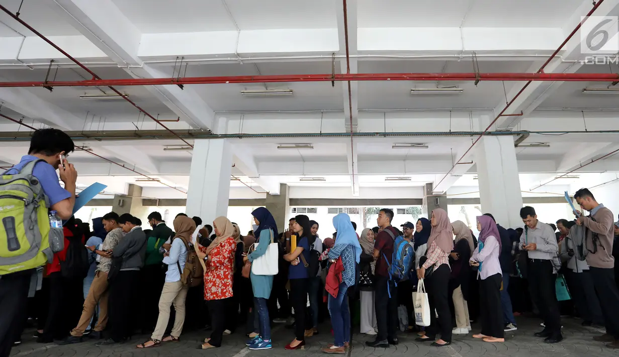 Peserta mengantre untuk pendaftaran ulang ujian CPNS Kementerian Kelautan dan Perikanan (KKP) di kawasan Gambir,  Jakarta, Minggu (8/10). Pendaftaran ujian CPNS ini untuk menempati berbagai formasi di KKP. (Liputan6.com/Johan Tallo)