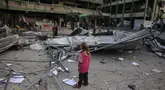 Seorang anak perempuan Palestina melihat reruntuhan sekolah Fatima Bint Asad yang dihantam serangan semalam oleh Israel di Jabalia, Jalur Gaza utara, Senin 12 Mei 2025. (Bashar TALEB/AFP)