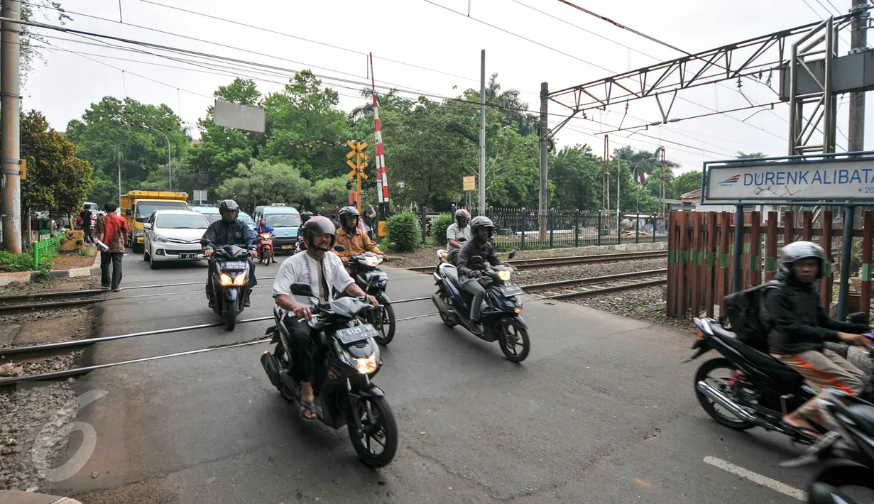 Pengendara motor melintasi palang pintu kereta di pintu pelintasan Kalibata, Jakarta, (4/12). Pemerintah DKI Jakarta berencana bangun jalan layang atau terowongan di pelintasan-pelintasan sebidang untuk mencegah kecelakaan. (Liputan6.com/Yoppy Renato)