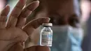 Petugas kesehatan memegang botol kosong kandidat vaksin Covid-19 Abdala buatan Kuba selama kampanye vaksinasi massal di kompleks Andres Blanco di Fuerte Tiuna, Caracas, Rabu (30/6/2021). Venezuela pada 24 Juni 2021 menandatangani kontrak untuk membeli 12 juta dosis vaksin Abdala. (Yuri CORTEZ/AFP)