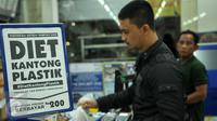 Konsumen membawa barang yang telah dibeli menggunakan kantong plastik di salah satu mini market di Pasar Baru, Jakarta, Senin (22/2). Pemerintah mulai menguji coba penerapan kantong plastik berbayar di ritel modern. (Liputan6.com/Gempur M Surya)