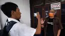 Ketua Pewarta Foto Indonesia (PFI) Reno Esnir (kanan) menyampaikan keterangan saat membagikan masker dan hand sanitizer kepada jurnalis foto di Jakarta, Jumat (20/3/2020). (Foto: Dok. Pewarta Foto Indonesia)