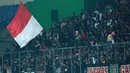 Suporter Timnas Indonesia memberikan dukungan kepada skuat Garuda dengan mengibarkan bendera Merah Putih saat laga uji coba internasional yang bertajuk FIFA Match Day antara Indonesia melawan Bangladesh di Stadion Si Jalak Harupat, Bandung, Rabu (01/06/2022). Pertandingan berakhir dengan skor kacamata. (Bola.com/M Iqbal Ichsan)