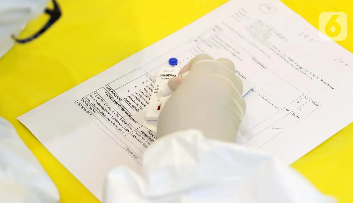 Petugas medis melakukan tes saat Rapid Test COVID-19 di Jakarta, Rabu (8/4/2020). Hasil akan memperlihatkan adanya IgG atau IgM dalam darah. Jika ada, maka hasil dinyatakan positif. Namun, hasil tersebut bukanlah diagnosis yang menggambarkan infeksi Covid-19. (Liputan6.com/Helmi Fithriansyah)