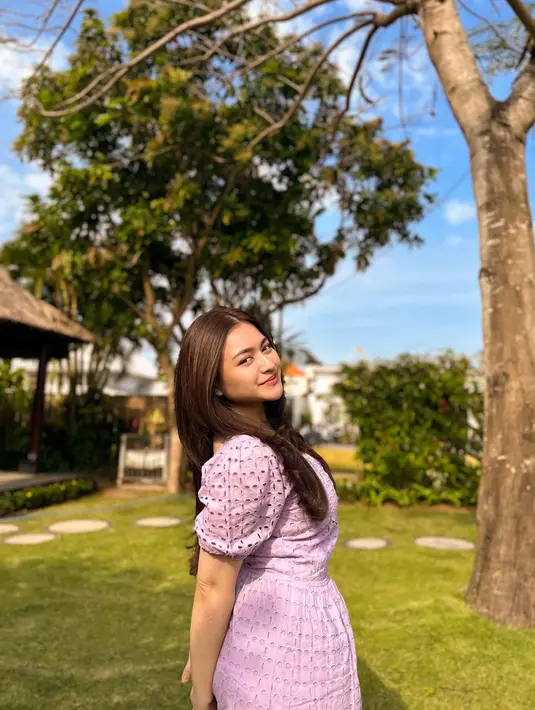 Kali ini memancarkan pesona feminin dengan dress berdetail puff sleeve warna pink muda. [Instagram/nathalieholscher]