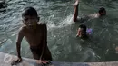 Anak-anak  berenang di kolam air mancur di kawasan Jalan Diponogoro, Jakarta, Jumat (31/7/2015). Minimnya lahan bermain di Ibukota, membuat mereka memanfaatkan kolam air mancur sebagai tempat berenang. (Liputan6/Johan Tallo)