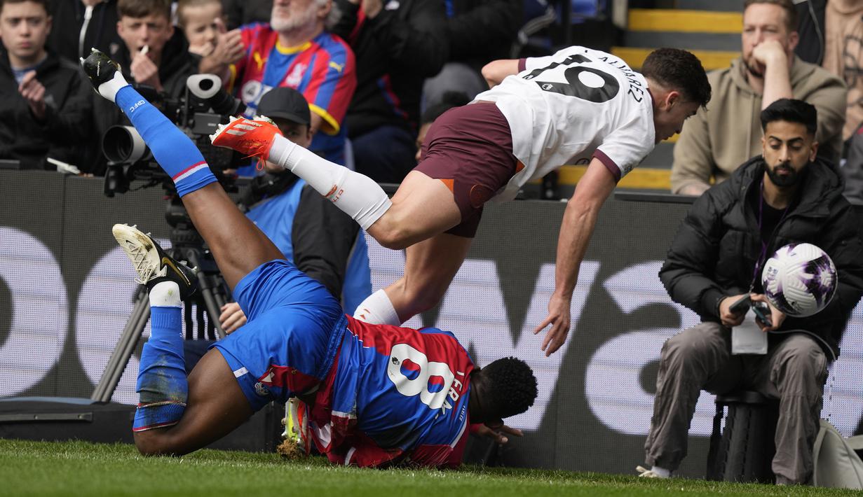 Striker Manchester City, Julian Alvarez (atas) dan gelandang Crystal Palace, Jefferson Lerma terjatuh usai perebutan bola pada laga pekan ke-32 Premier League 2023/2024 di Selhurst Park stadium, London, Sabtu (6/4/2024). (AP Photo/Frank Augstein)