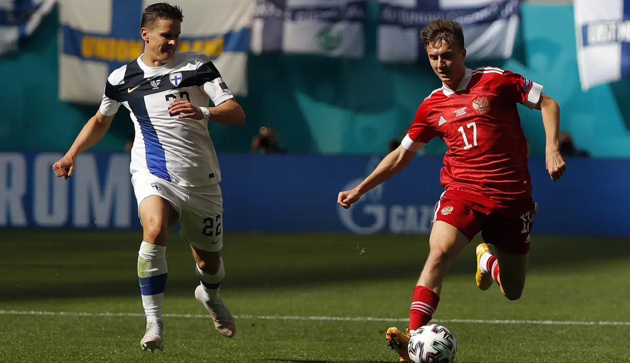 Gelandang Rusia, Aleksandr Golovin membawa bola dari kejaran pemain Finlandia, Jukka Raitala pada pertandingan grup B Euro 2020 di stadion Gazprom Arena di St. Petersburg, Rusia, Rabu (16/6/2021). Hasil ini membuat jalan Rusia lolos ke 16 besar kembali terbuka. (Evgenia Novozhenina/Pool via AP)
