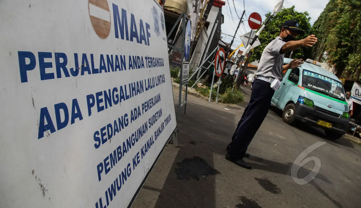 Petugas mengatur lalu lintas di jalan yang terkena pengalihan arus di kawasan Otista, Jakarta, Kamis (23/4). Jalan Otto Iskandardinata 3 akan ditutup selama 70 hari karena pembangunan sodetan Kali Ciliwung kembali dilanjutkan. (Liputan6.com/Faizal Fanani)