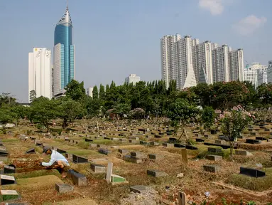 Pekerja tengah membersihkan area makam di TPU Karet Bivak, Jakarta, Kamis (2/10/14). (Liputan6.Com/Faizal Fanani)