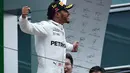 Pembalap Mercedes Lewis Hamilton merayakan kemenangan setelah berhasil memenangi balapan GP China di Sirkuit Internasional Shanghai, Minggu (9/4). Lewis Hamilton jadi pemenang di GP China, dengan Sebastian Vettel di posisi runner-up. (WANG Zhao/AFP)