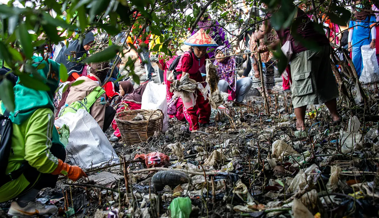 Anak-anak memungut sampah yang berserakan di sekitar kawasan pantai di Surabaya, Jawa Timur, Sabtu (21/9/2019).Aksi tersebut sebagai wujud kepedulian terhadap kebersihan lingkungan sekaligus dalam rangka memperingati World Cleanup Day 2019.  (JUNI KRISWANTO / AFP)