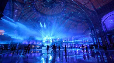 Orang-orang berseluncur di arena ice skating di bawah kubah kaca mewah legendaris, Grand Palais, Paris, Selasa (17/12/2019). Aren seluncur es musiman ini terbuka untuk umum selama liburan Natal. (Photo by Thomas SAMSON / AFP)