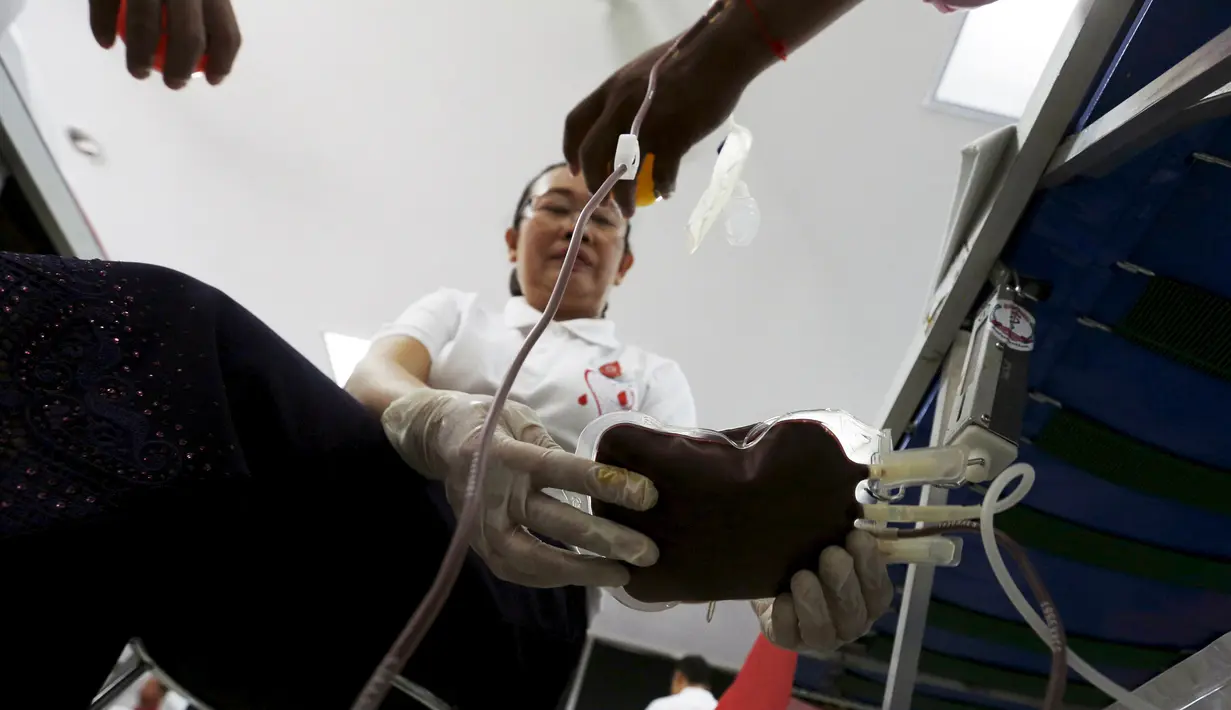 Petugas sedang melihat kondisi kantong darah saat "Give Blood Give Love" untuk merayakan Hari Valentine di Phnom Penh, Kamboja (14/2/2016). Acara ini dilakukan untuk menunjukan bahwa masyarakat memiliki rasa kemanusiaan. (Reuters/Samrang Pring)