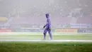 Seorang petugas sedang mengecek lapangan pertandingan di bawah guyuran hujan dalam laga final Pegadaian Liga 2 2024/2025 antara Bhayangkara FC melawan PSIM Yogyakarta di Stadion Manahan, Solo, Jawa Tengah, Rabu (26/02/2025). (Bola.com/Abdul Aziz)