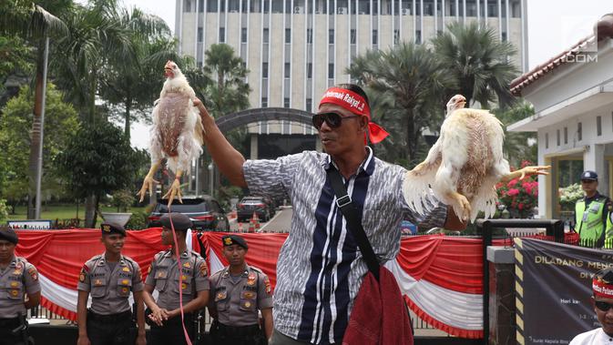 Peternak membawa ayam dalam aksi di depan Kementerian Koordinator Bidang Perekonomian, Jakarta, Kamis (5/9/2019). Ratusan peternak ayam menuntut pemerintah turun tangan menyelesaikan permasalahan harga ayam hidup di tingkat peternak yang kembali anjlok. (Liputan6.com/Angga Yuniar)