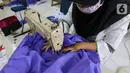 Peserta pelatihan memproduksi alat pelindung diri (APD) berupa pakaian dekontaminasi atau baju hazmat di Balai Latihan Kerja (BLK), Cibodas, Kota Tangerang, Rabu (15/4/2020). BLK mampu memproduksi baju hazmat berbahan Polypropylene Spundbound sekitar 20 baju perhari. (Liputan6.com/Fery Pradolo)