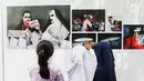 Siswa SD Negeri Menteng 01 mengamati karya foto yang dipamerkan dalam pameran fotografi Rekam Jakarta di Taman Menteng, Kamis (29/8/2019). Kegiatan tersebut dalam rangka edukasi bagi siswa mengenal profesi foto jurnalistik. (Liputan6.com/Marsha Aulia)