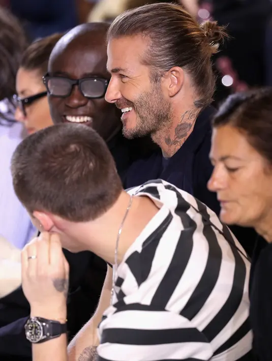 David Beckham dan putranya Brooklyn menyaksikan fashion show koleksi musim panas Victoria Beckham di New York Fashion Week, Minggu (10/9). David berada di barisan terdepan bersama sang putra  untuk menujukkan support mereka. (EDUARDO MUNOZ ALVAREZ / AFP)