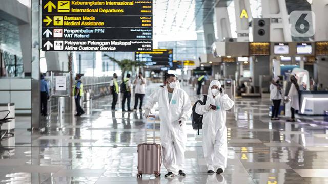 FOTO: Cegah Corona, Calon Penumpang di Bandara Soetta Pakai APD