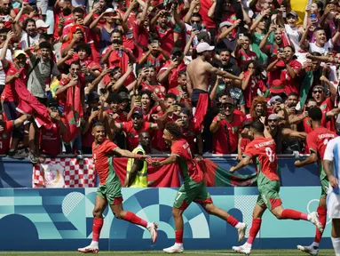 Para pemain Maroko merayakan gol yang dicetak oleh Soufiane Rahimi ke gawang Argentina pada laga pertama grup B Olimpiade 2024 di stadion Geoffroy-Guichard, Rabu (24/7/2024). Argentina tumbang dengan skor 1-2. (AP Photo/Silvia Izquierdo)