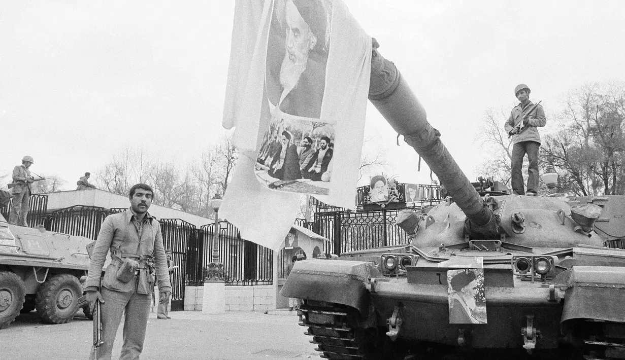 Gambar pemimpin spiritual Iran, Ayatollah Khomeini digantung pada laras tank di depan Istana Niavaran, Teheran, Iran, 13 Februari 1979.  (AP Photo/Aristoteles Saris, File)
