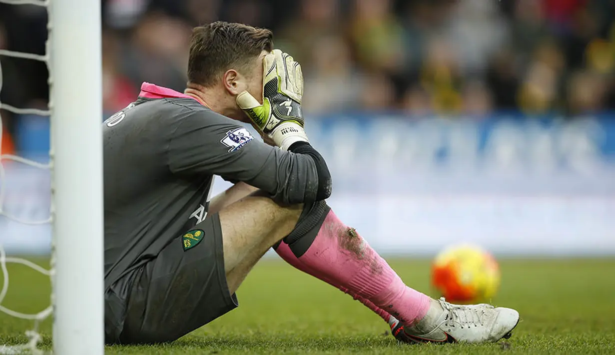 Kiper Norwich, Declan Rudd, tertunduk lesu usai kebobolan dari pemain Liverpool, Adam Lallana. Pada laga seru itu tercipta dua gol pada saat perpanjangan waktu. (Reuters/John Sibley)