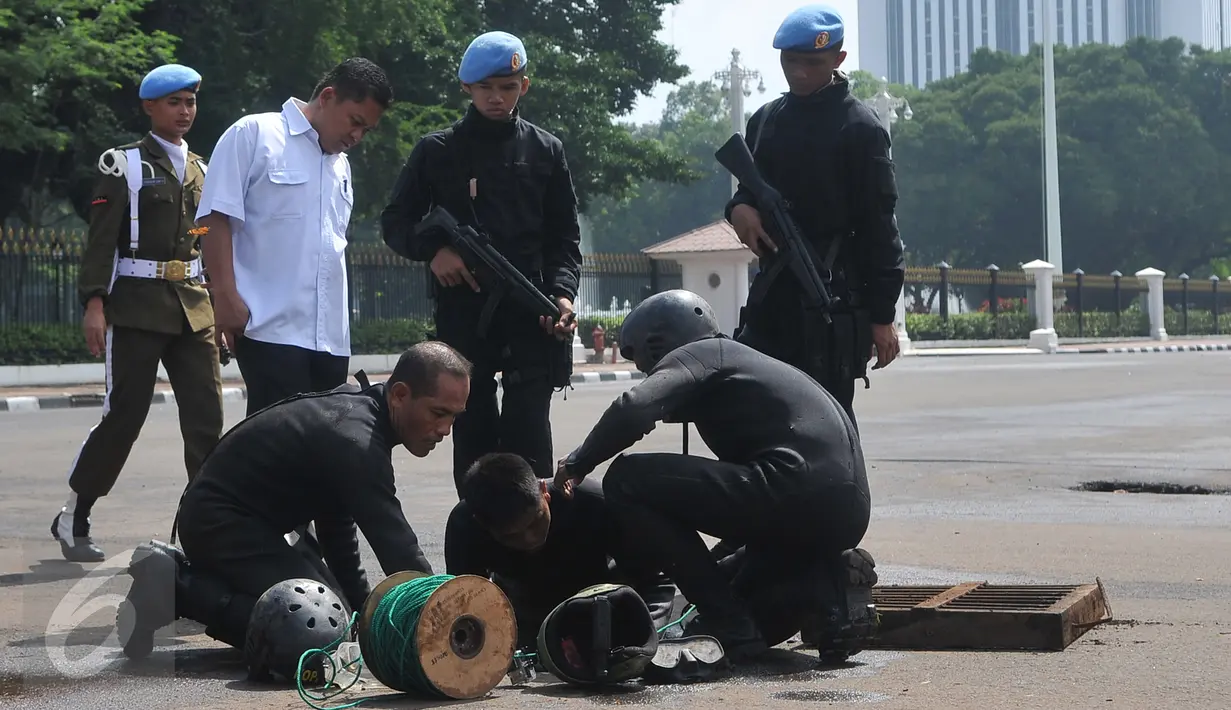 Pasukan katak TNI AL mempersiapkan peralatan untuk menyusuri gorong-gorong di depan Istana Merdeka, Jakarta, Kamis (3/3). Pasukan katak ini dilibatkan menyusul temuan kulit kabel yang sebelumnya ditemukan di gorong-gorong. (Liputan6.com/Gempur M Surya)