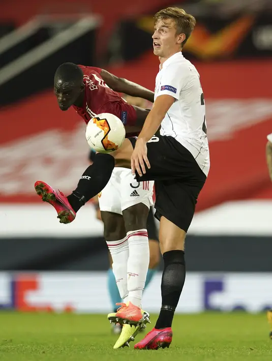 Bek Manchester United, Eric Bailly berebut bola dengan pemain LASK, Marko Raguz pada pertandingan leg kedua babak 16 besar Liga Europa di Stadion Old Trafford, Inggris (6/8/2020). MU menang 2-1 atas Lask dan melaju ke perempat final.  (AP Photo/Dave Thompson)
