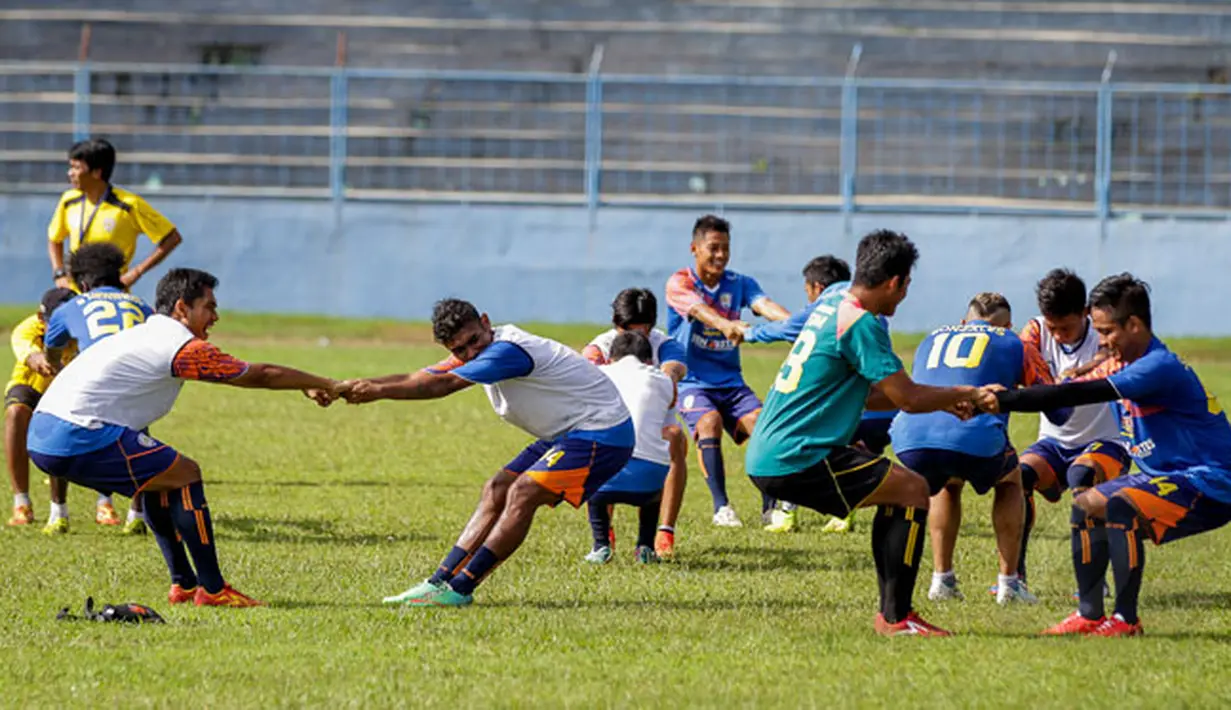 Sejumlah pemain Arema Cronus menggelar latihan di Stadion Gajayana, Malang, Sabtu pagi (17/1/2015). Tampak, pemain Arema Cronus melakukan peregangan otot jelang berlatih. (Liputan6.com/Faizal Fanani)