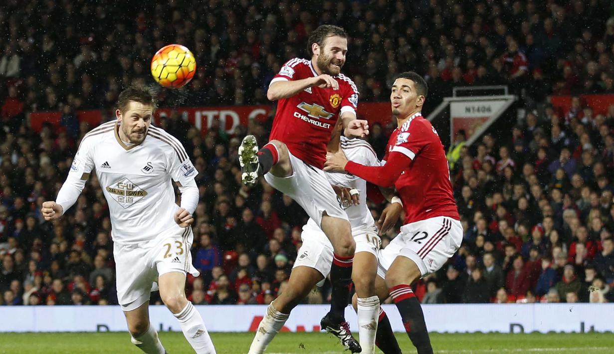  Pemain Swansea City, Gylfi Sigurdsson menyudndul bola melewati hadangan para pemain Manchester United pada lanjutan Liga Premier Inggris di Stadion Old Trafford, Sabtu (02/01/2016). Manchester United menang 2-1. (Reuters/Carl Recine)