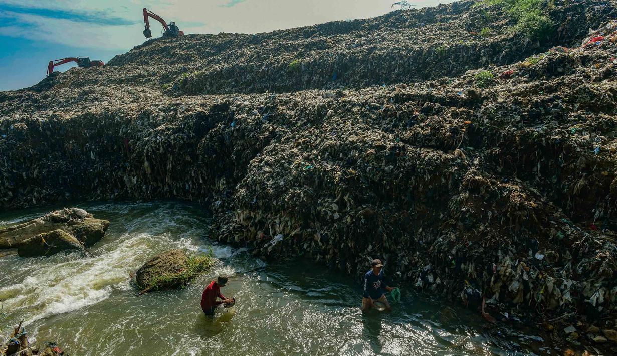 Warga memanfaatkan aliran Kali Pesanggrahan yang menyempit untuk mendulang benda-benda logam di kawasan Pasir Putih, Depok, Jawa Barat, Senin (27/4/2026), setelah longsoran sampah dari Tempat Pembuangan Akhir (TPA) Cipayung menutup sebagian badan sungai. (merdeka.com/Arie Basuki)