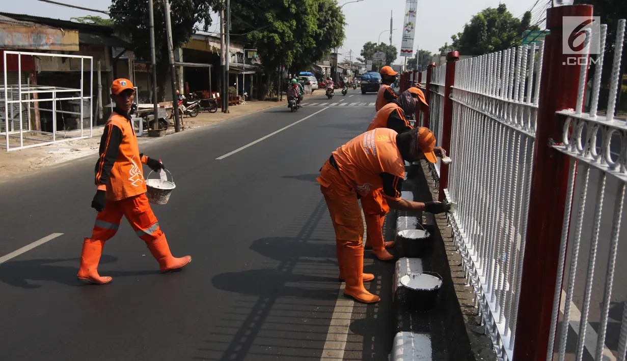 Petugas PPSU Kelurahan Kramat Jati mengecat ulang pagar pembatas Jalan Raya Bogor, Jakarta, Selasa (17/7). Pengecatan sebagai upaya perawatan berkala terhadap sarana dan prasarana yang sudah mulai kehilangan fungsi atau rusak. (Liputan6.com/Arya Manggala)